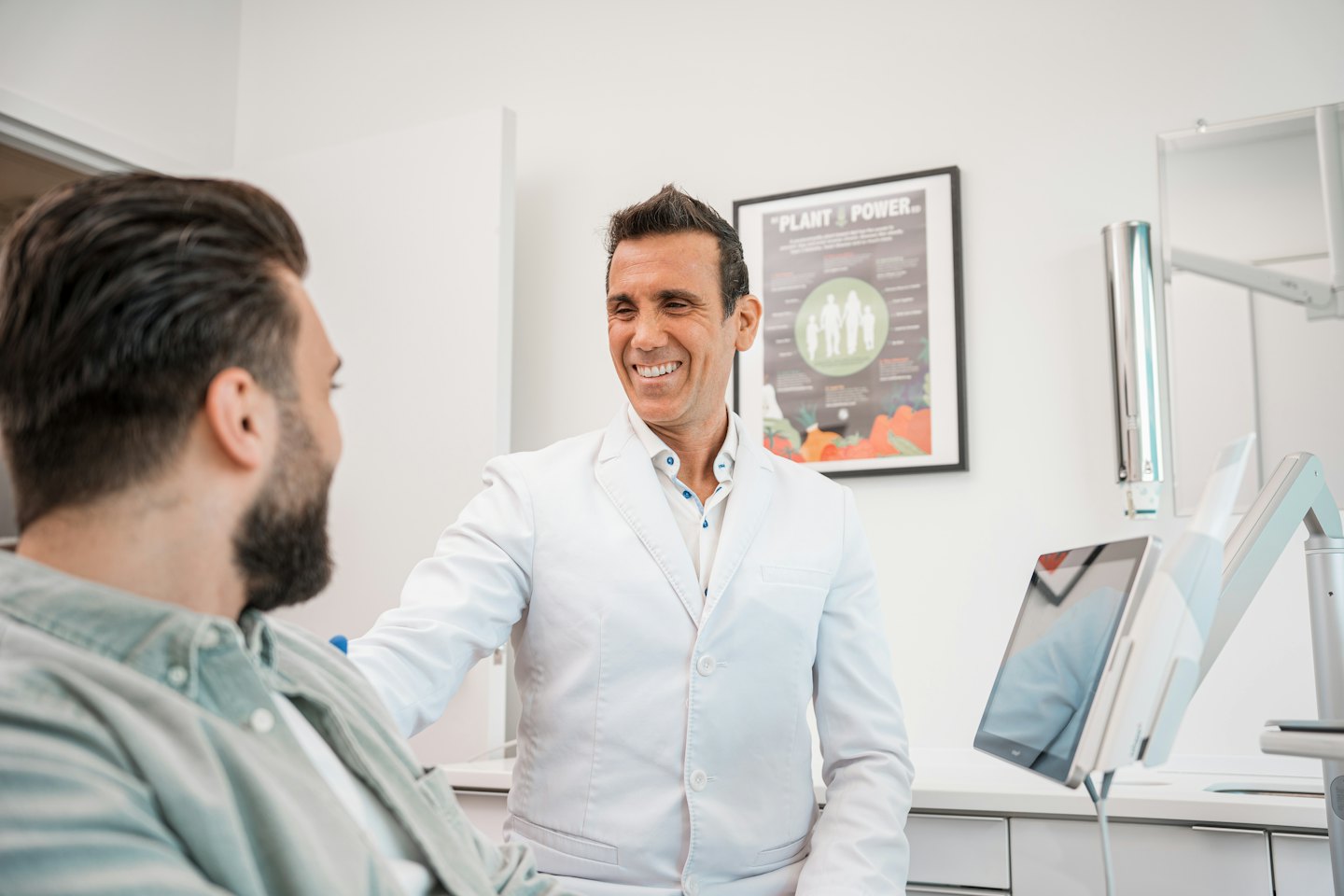 Doctor smiles while talking to patient in a modern clinic.
