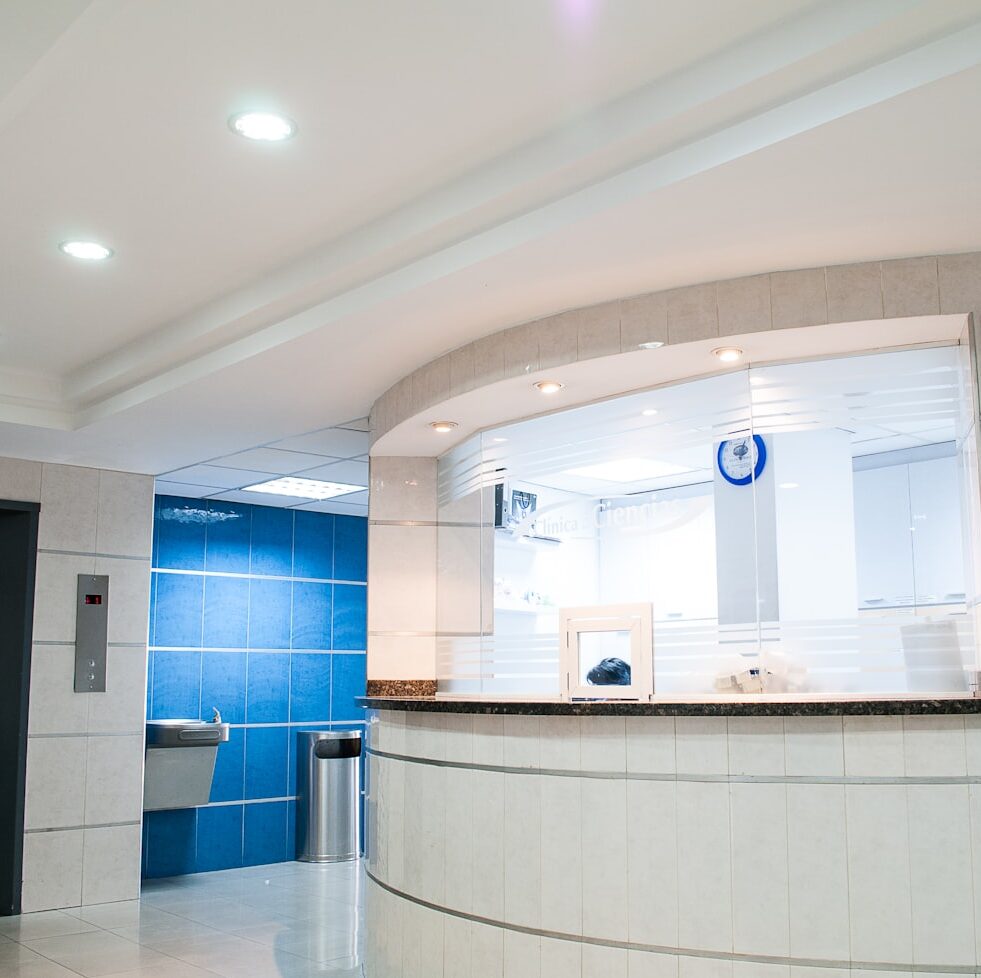 Modern reception area with curved desk and blue tiles.